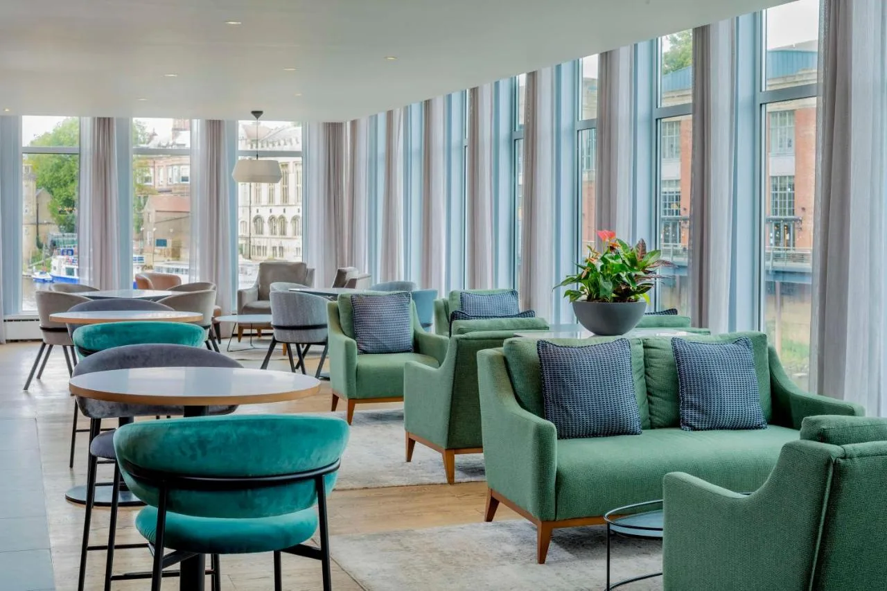 Green chairs and tables by the windows at Radisson Hotel York